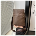 Detailed view of brown litchi pattern leather crossbody bag with wide shoulder strap - Coffee