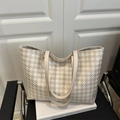 Detail of autumn houndstooth tote bag with woven texture and light leather handles - Khaki