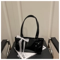 Detail der glänzenden schwarzen Boston Bag mit weißer Spitzenschleife und Silbernieten - Schwarz