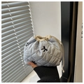 Detailed view of light blue quilted makeup bag with black floral embroidery and drawstring - Blue