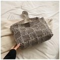 Macro view of geometric pattern fabric and textured strap on a vintage square shoulder bag - Black