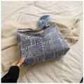 Detail of blue and white geometric woven handbag with textured pattern and shoulder strap - Blue