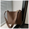 Detail of wide eyelet shoulder strap with gold buckle on brown leather bucket bag - Coffee