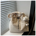Detail der cremefarbenen Kordelzugtasche mit süßem Wolken-Plüschanhänger am Fenster - Mit Anhänger / Khaki