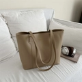 Bolso tote grande minimalista de cuero caqui para mujer en sofá blanco con accesorios - Caqui