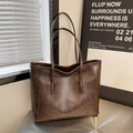 Borsa tote vintage marrone scuro in finta pelle su un tavolo minimalista - Marrone