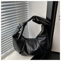Detail of black pleated hobo bag featuring litchi grain texture and knotted wide strap - Black