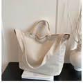 Detailed close-up of cream corduroy tote bag showing ribbed texture and shoulder strap - White
