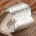 Polished silver textured cuff bracelet in wave design on elegant bronze display - Silver (F2698)