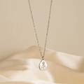 Collier avec pendentif rose ovale en acier inoxydable sur fond de soie beige - Style Rose Goutte d'argent (F1868)