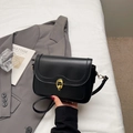 Bolso bandolera negro clásico con hebilla de anillo dorada en un fondo neutro elegante - Negro