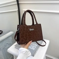 Detailed view of dark brown leopard print tote with silver metal logo and leather texture - Brown