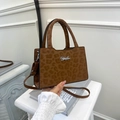 Brown leopard print handbag with silver logo and adjustable crossbody strap on white marble - Brown