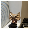 Close-up of beige mini bag with oversized bow and elegant pearl handle strap - Khaki