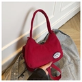 Dettaglio della borsa a tracolla in velluto rosso con badge Dake Duck e trama a coste - Senza Ciondolo / Rosso