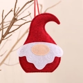 Red felt Christmas gnome ornament with scroll beard hanging on a natural branch - Red