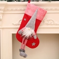 Christmas stocking with grey gnome doll decoration hanging on a white fireplace - Red