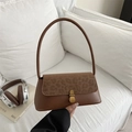 Braune Retro-Schultertasche mit Leopardenmuster-Klappe auf einem weißen Sofa - Hellbraun