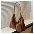 Braune Shopper-Tasche aus Wildleder mit passender Mini-Tasche im natürlichen Fensterlicht - Kaffeebraun
