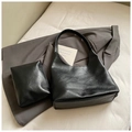 Dettaglio del set borsa hobo in pelle nera opaca con pochette abbinata su sfondo in tessuto - Borsa A Tracolla E Pochette (Nero) / Nero