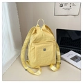 Light yellow nylon backpack with pleated texture and adjustable straps on a desk - Yellow