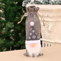 Grey burlap Christmas gnome wine bottle cover with snowflake hat and drawstring closure - Gray