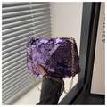 Detail view of purple sequin handbag with gold chain strap and luxury texture - Purple