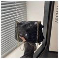 Close-up of black sequined evening clutch bag with elegant gold chain strap detail - Black