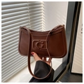 Close-up of retro brown leather shoulder bag featuring embossed G letter and gold hardware - Brown