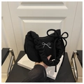 Detailansicht der schwarzen Cord-Tasche mit weißer Schleifenstickerei und Seidenband-Akzenten - Schwarz
