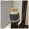 Detail of blue woven bucket bag with pearl handle and cream drawstring closure - Blue
