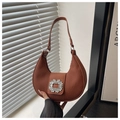 Close-up of pleated caramel crescent bag with a sparkling oversized rhinestone buckle - Brown