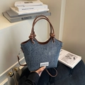 Dettaglio della borsa a secchiello in denim vintage con manici in pelle e nodi decorativi - Marrone