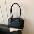 Minimalist black matte leather tote bag for women with dual straps shown on a chair - Black