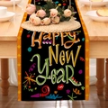 Close-up of Happy New Year linen table runner with gold stars on a wooden dining table - Black Script New Year Wishes Style (24ZQ12-10)