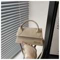 Detail der hellbeigen Wildleder-Minibag mit goldenem Metall-Logo und feiner Verarbeitung - Khaki