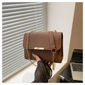 Detalle del bolso marrón con textura trenzada, cadena dorada y hebilla metálica - café