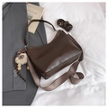 Detail of dark brown tote bag with patterned strap, fashion lettering and plush charm - With Pendant / Brown