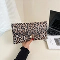 Macro detail of leopard print envelope clutch featuring a glossy gold metallic buckle - Black Leopard