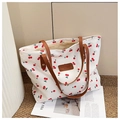 Détail du sac cabas en toile avec imprimé cerise et bandoulières en cuir marron - Blanc
