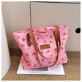 Détail du sac cabas rose à imprimé cerises avec anses en cuir et écusson de la marque - Rose
