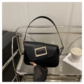 Detalle de bolso de hombro en cuero negro con hebilla cuadrada dorada sobre estante - Negro