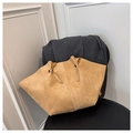 Detail view of khaki suede tote bag featuring winged design on a black leather chair - Khaki