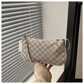 Dettaglio della borsa beige con motivo a lettere M grigie e targhetta alla moda - Bianco