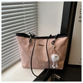 Dettaglio della borsa tote rosa con trama pieghettata, manici neri e ciondolo peluche - Rosa Con Ciondolo