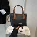 Borsa a secchiello nera texture litchi minimalista con manico marrone a contrasto - Nero