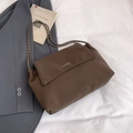 Brown leather shoulder bag with chain strap and flap closure on white fabric - Brown