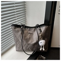Close-up of gray marble texture tote bag with black straps and plush white charm - Gray With Pendant