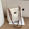 White faux fur bucket tote bag with brown leather patch and straps on a minimal rug - Off White