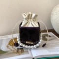Detail of purple crocodile-pattern bucket bag with large pearl handle and chain strap - Purple